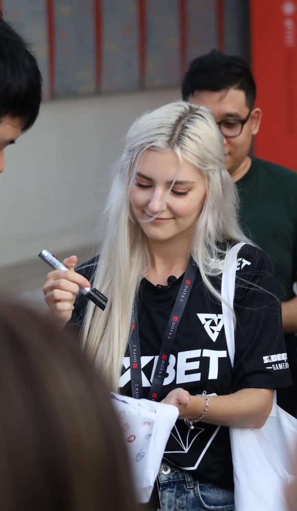 Bất đồng ngôn ngữ nhưng cô nàng không hề e ngại chụp ảnh hay ký tặng fan (ảnh: Khaosod E-Sports).