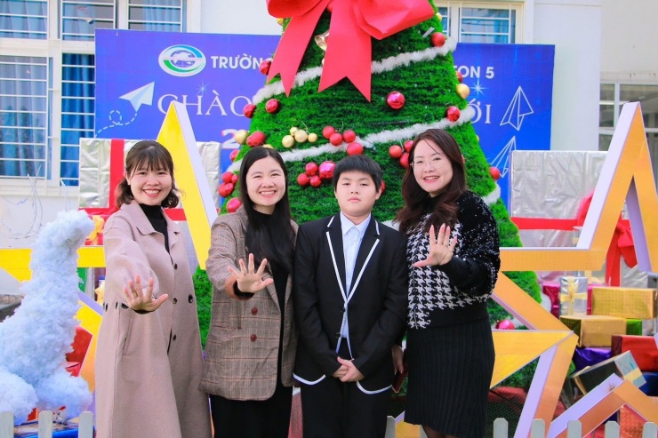 1735352967-z1-aaf59dbc5ae8db9efc6ab58569-70048-width1757height1171 Hải Nam cùng Hiệu trưởng Lê Thị Thanh Nhàn (bìa phải) và các giáo viên của Trường Tiểu học - THCS Newton 5.