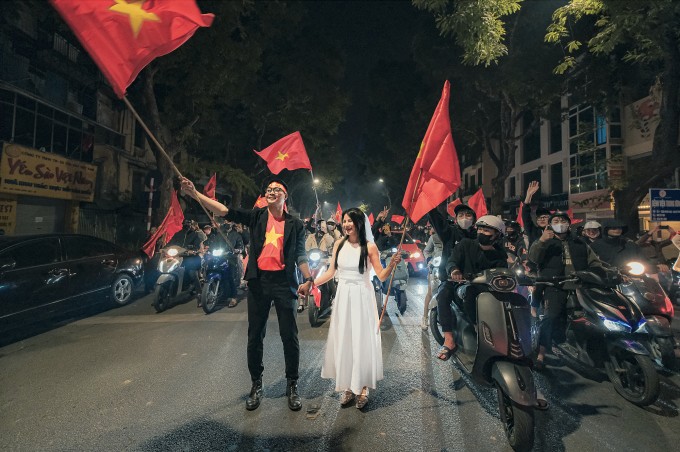 1736153637-anh-man-hinh-2025-01-06-luc-13-5047-6641-4996-width680height452 Đình Minh và Hương Ly phất cờ, cùng hòa mình vào dòng người đi bão trên phố Bà Triệu, quận Hoàn Kiếm, tối 5/1. Ảnh: Quang Anh