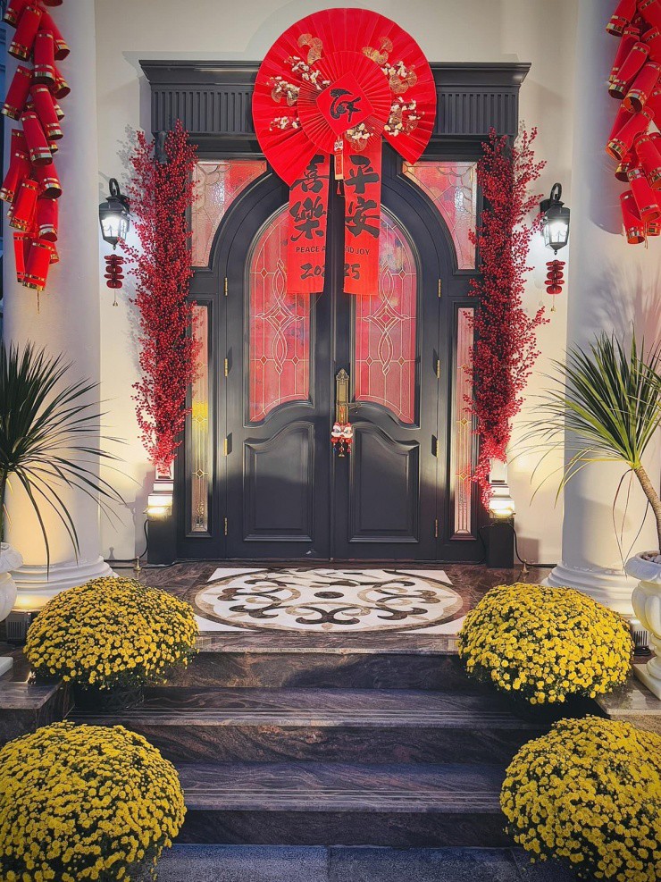 1737344074-2-6605-width1200height1600 Cửa ra vào của căn biệt thự đặt những chậu cúc và trang hoàng bằng tràng pháo đỏ, hoa đào đông, câu đối, quạt giấy... tạo cảm giác ấm cúng, sinh động.