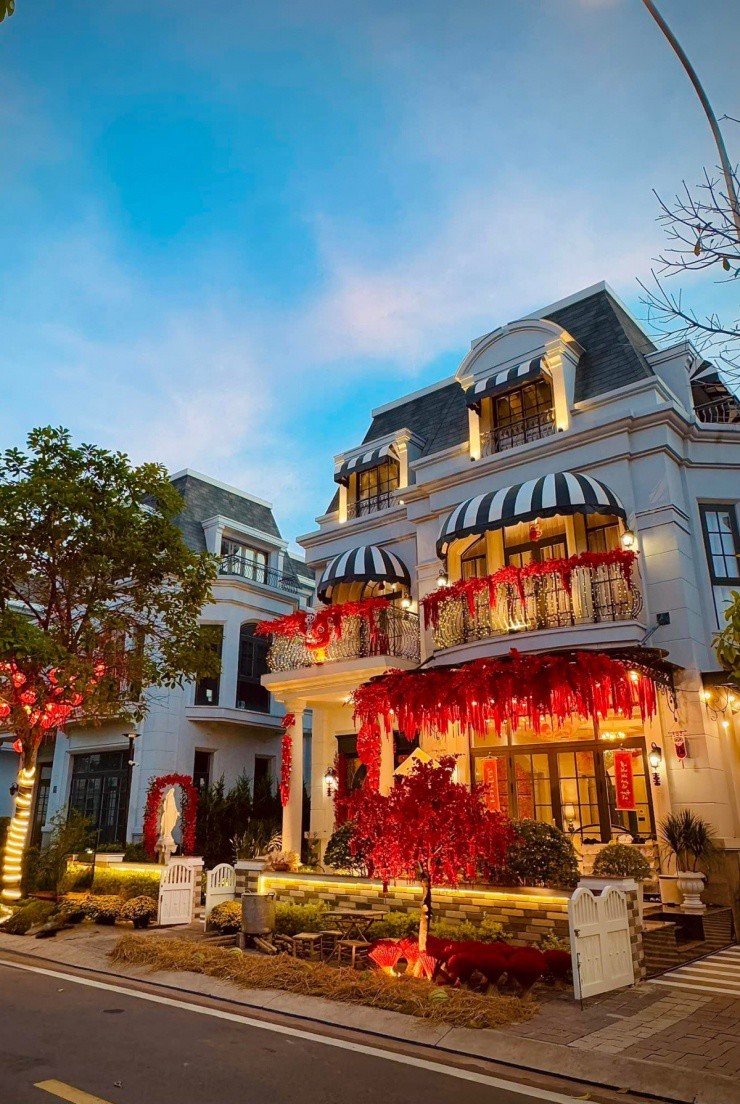 1737702275-6-3655-width1200height1799 Gia đình Đoàn Di Băng hiện sống trong cơ ngơi ba tầng, có diện tích sàn khoảng 300 m2 ở huyện Nhà Bè, TP HCM. Ca sĩ cho biết Tết năm nay cô lên ý tưởng trang trí nhà theo tông màu đỏ chủ đạo từ ngoài vào trong, cầu may mắn, bình an cho bản thân và gia đình. Cửa ra vào của căn biệt thự đặt những chậu cúc và trang hoàng bằng trang pháo đỏ, hoa đào đông, câu đối, quạt giấy.