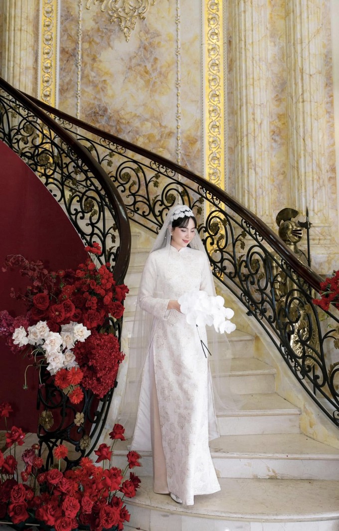 1737784837-mc-mai-ngoc-dam-cuoi-5-6-8787-4722-7663-6-9011-width680height1065 Mai Ngọc tạo dáng tại bậc tam cấp của nhà chồng sau lễ rước dâu. Theo nữ MC, mẹ chồng cô chăm chút từng chiếc tráp cưới và không gian trong nhà với tông đỏ nổi bật, sang trọng tượng trưng cho sự may mắn. Chỉ một góc cầu thang đơn giản cũng góp phần thể hiện được sự nguy nga bề thế của biệt thự nhà chồng Mai Ngọc.