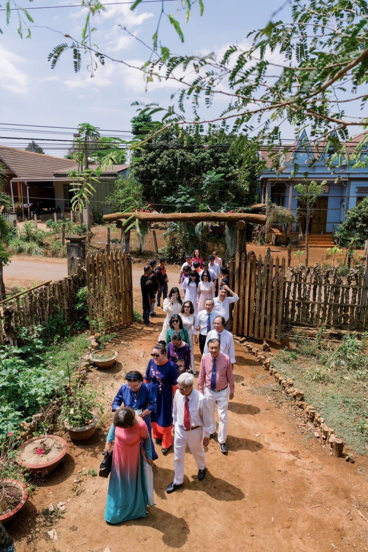 Hình ảnh đoàn 20 người nhà trai tiến vào nhà H'Hen Niê làm lễ. Cổng hoa chỉ trang trí đơn giản, giữ lại hoàn toàn vẻ đơn sơ, mộc mạc của cuộc sống người vùng cao.