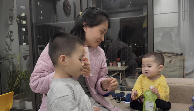 Bé Đậu (áo vàng) bên mẹ và em trai tại nhà riêng, ở Yên Nghĩa, Hà Đông, Hà Nội, hôm 30/3. Ảnh: Phạm Nga