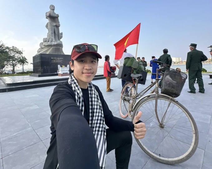 Quang Hà chụp ảnh kỷ niệm tại tượng đài Mẹ Suốt, Quảng Bình hôm 12/4, trong hành trình đạp xe từ Hà Nội vào TP HCM. Ảnh: Nhân vật cung cấp