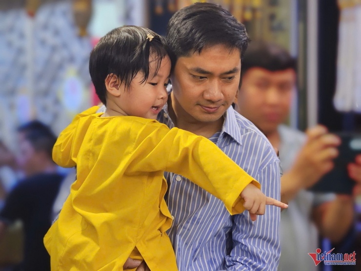 Khi nghệ sĩ Minh Luân bế đến bàn thờ Quý Bình, Eric ngây ngô chào cha, tròn xoe mắt trước các vật phẩm, hoa tươi được bày biện.