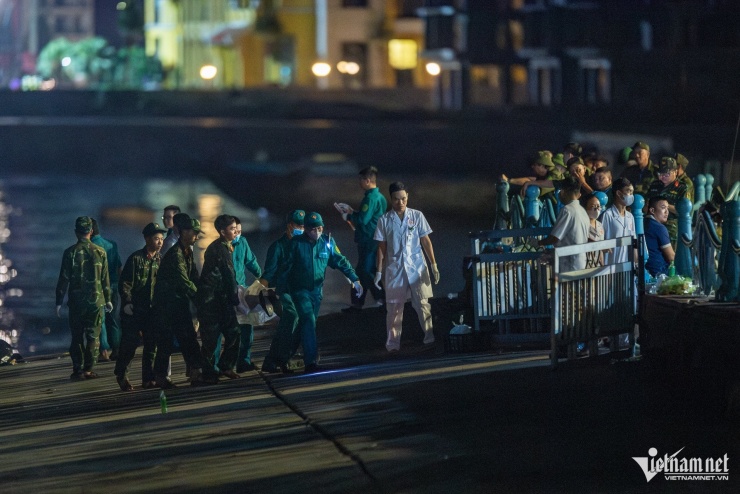 Lực lượng chức năng đưa thi thể nạn nhân vụ lật tàu lên bờ, rạng sáng 20/7. Ảnh: Đức Anh 