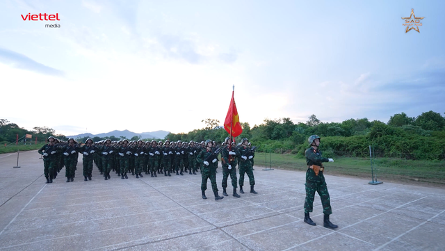 Hình ảnh Thượng úy Lê Hoàng Hiệp thực hiện nghi thức rước cờ trong đội hình Lữ đoàn Tác chiến điện tử. Ảnh: NSX