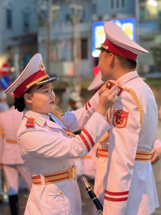 Chị Nguyễn Thị Phương Thanh chỉnh lại quân phục cho chồng, anh Dương Thanh Bình, 30 tuổi, công tác tại Đoàn Nghi lễ Quân đội, chiều tối 21/8 trên phố Ngọc Hà. Ảnh nhân vật cung cấp