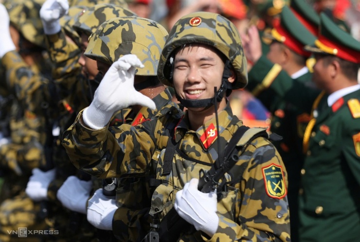 Tại sân Quần Ngựa, chiến sĩ Công binh tay bồng súng, tay tạo hình trái tim, cười tươi đáp lễ những cổ động viên nhiệt tình suốt từ hôm tổng hợp luyện ngày 21/8 đến giờ. Ảnh: Đức Đồng