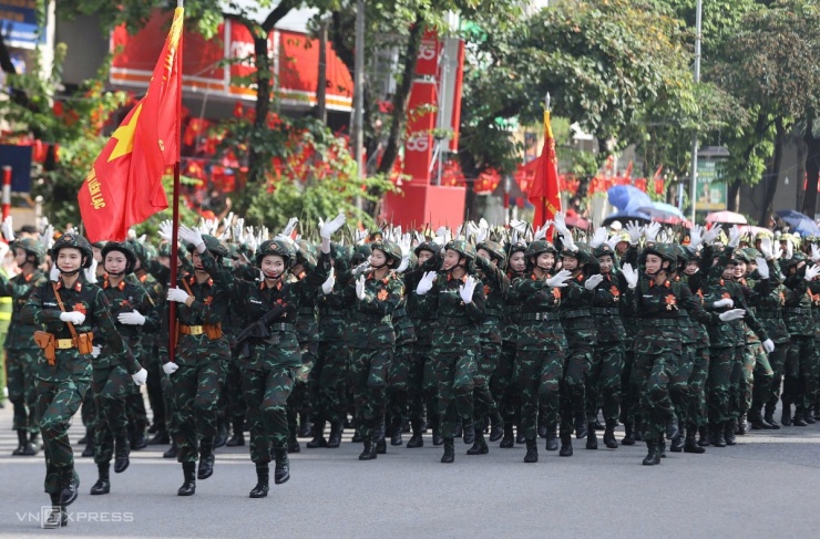 Vừa bước đều, các nữ sĩ quan thông tin liên lạc vừa vẫy tay chào người dân bên đường. Ảnh: Đức Đồng