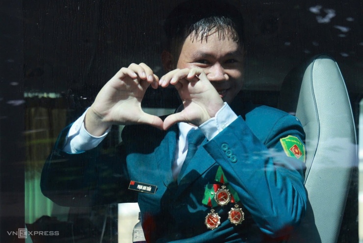 Lên xe trở về đơn vị, nam chiến sĩ dân quân tự vệ không quên thả tim đáp lại những cánh tay vẫy chào tạm biệt của người dân. Ảnh: Đức Đồng