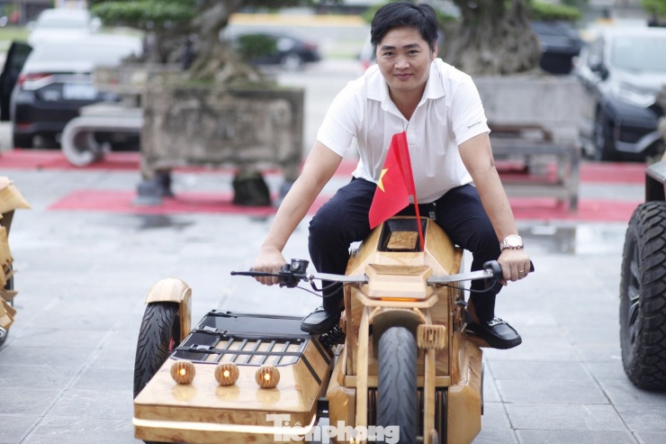 Một người dân đi thử xe mô tô bằng gỗ. Ảnh: Nguyễn Thắng