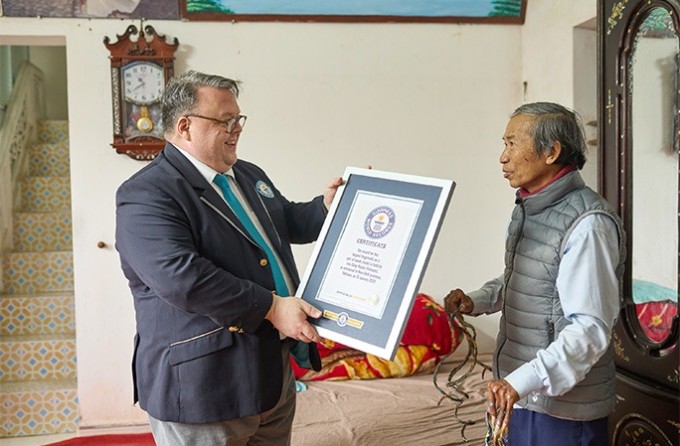 Craig Glenday trao chứng nhận Kỷ lục Guinness cho ông Huyền. Ảnh: Guinness World Record