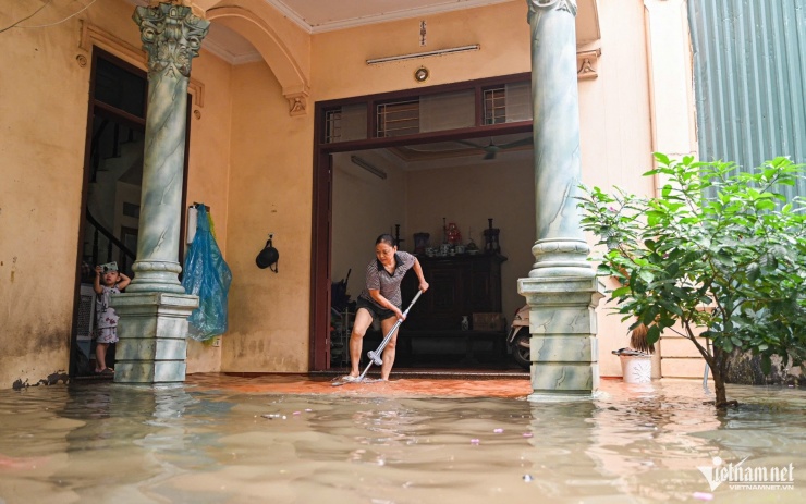 Nước ngập hết sân, tới sát mép nền phòng khách của gia đình bà Châm. Ảnh: Huy Nguyễn