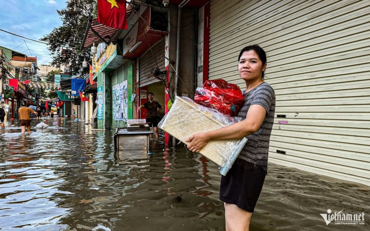 1759370030-w-ngap-phu-do-ha-noijpg-384-width1920height1200 Chị Chi lội nước bê đồ đi di tản. Ảnh: Huy Nguyễn
