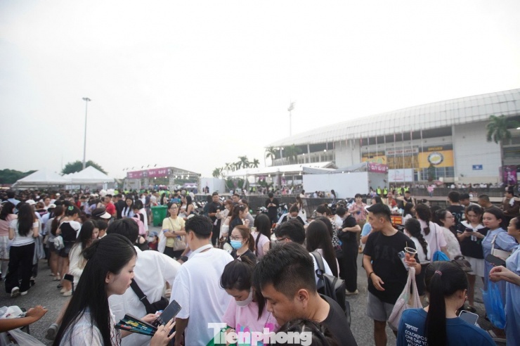 Khu vực trước cổng sân đông nghịt người. Các dịch vụ ăn uống, bán phụ kiện đắt hàng. Nhiều người chủ động chuẩn bị áo mưa khi xem concert.