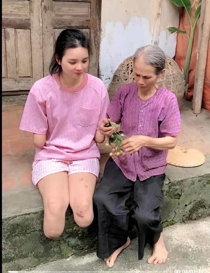 Trần Thị Nga và bà nội ngồi trước hiên nhà, tháng 6/2025. Ảnh cắt từ video