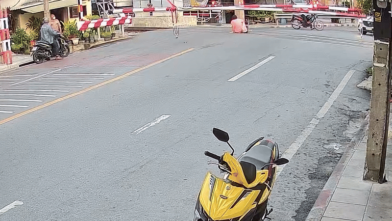 Cố vượt qua rào chắn tàu hỏa, người đàn ông khiến vợ gặp họa, camera an ninh ghi lại cảnh đáng sợ- Ảnh 2. Cố vượt qua rào chắn tàu hỏa, người đàn ông khiến vợ gặp họa, camera an ninh ghi lại cảnh đáng sợ- Ảnh 2.