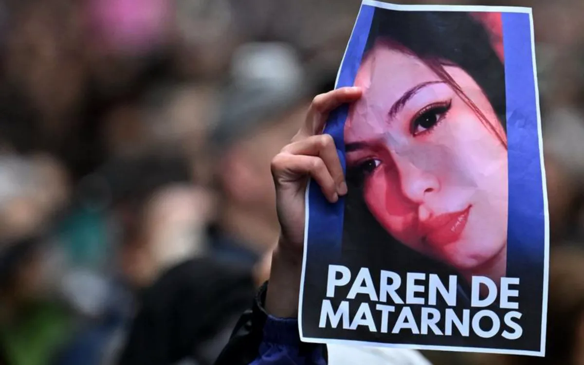 Ngườ biểu tình cầm ảnh Morena Verdi - một trong ba cô gái bị sát hại dã man (Ảnh: AFP)