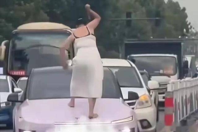 Người phụ nữ cầm gậy đập phá ô tô gây náo loạn trên phố- Ảnh 1.