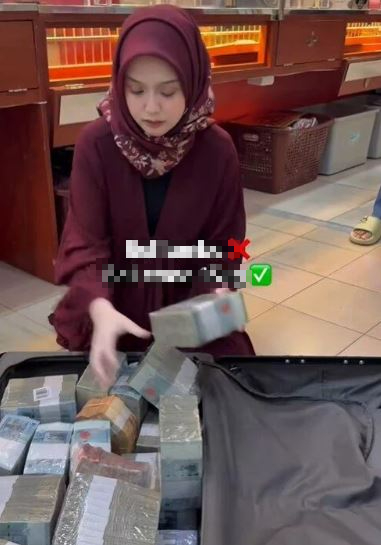 Xôn xao hình ảnh người phụ nữ mang vali tiền mặt để mua 15kg vàng ở Malaysia- Ảnh 1.