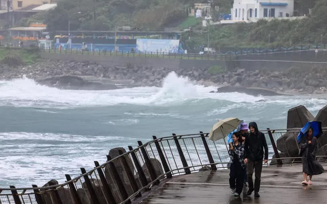Người dân sử dụng ô để che mưa và gió ở Keelung, Đài Loan (Trung Quốc) ngày 10/11 khi cơn bão Fung-wong đang tiến gần (Ảnh: AFP)