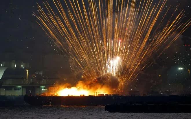 Pháo hoa bắn loạn xạ từ một sà lan đang bốc cháy tại lễ hội mùa hè ở Yokohama, tối 4/8 (Ảnh: Kyodo)