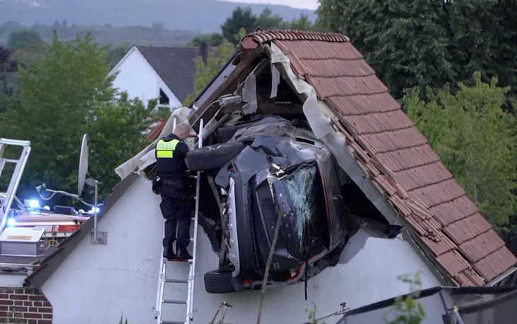 Ô tô mắc kẹt trên mái nhà kho sau vụ tai nạn ở Bohmte, Đức, ngày 20/7/2025 (Ảnh: AP)