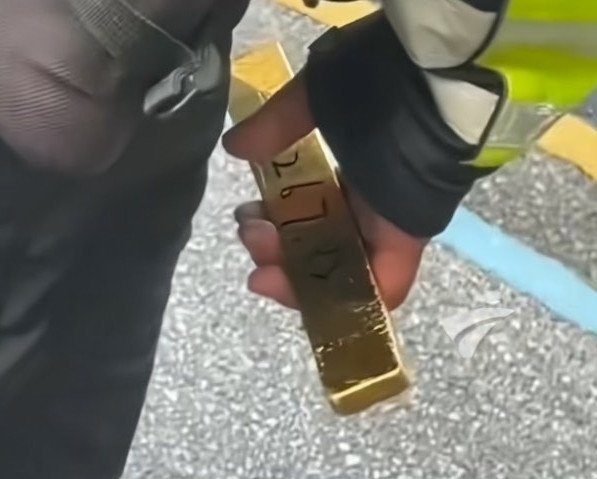 shipper-17-tuoi-nhat-duoc-thoi-vang-2-1758180815-248-width597height479 Xiao Xie (áo đen) giao nộp thỏi vàng cho sĩ quan Hou Guodong ngay sau khi nhặt được. Ảnh: HK01