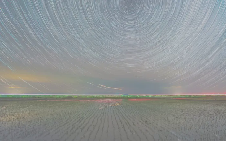 Bức ảnh ghép chồng cho thấy một cánh đồng lúa dưới bầu trời đầy sao ở thành phố Song Áp Sơn, tỉnh Hắc Long Giang, đông bắc Trung Quốc. (Ảnh minh họa: Xinhua)