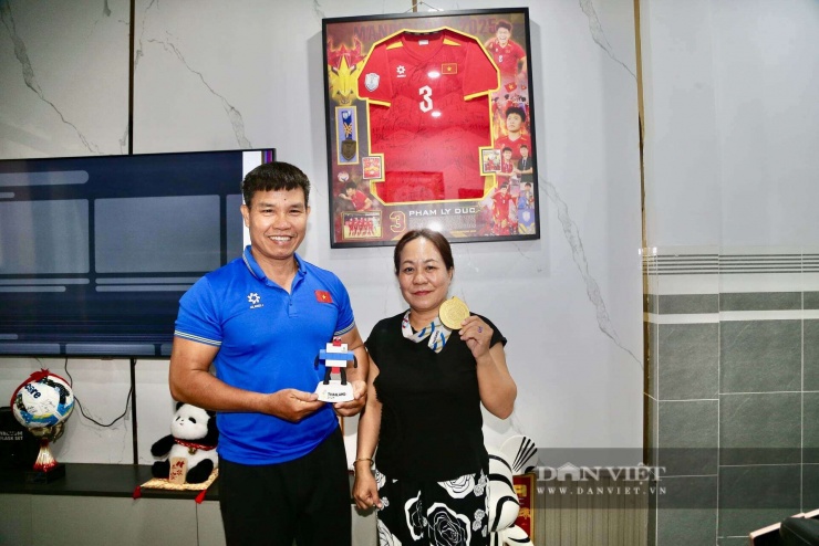 Ba mẹ Phạm Lý Đức cùng chiếc HCV và linh vật SEA Games 33 mà con trai mang về. Phía sau là chiếc tivi