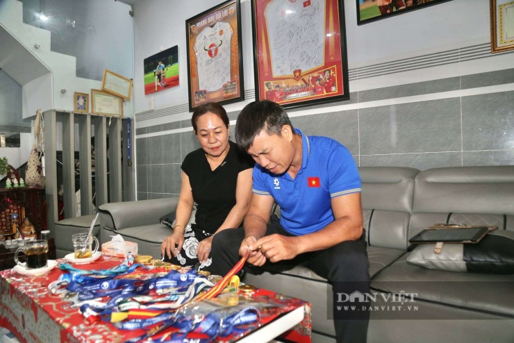 Ba mẹ trung vệ Phạm Lý Đức tự hào bên những chiếc huy chương mà con trai giành được. Ảnh: LG