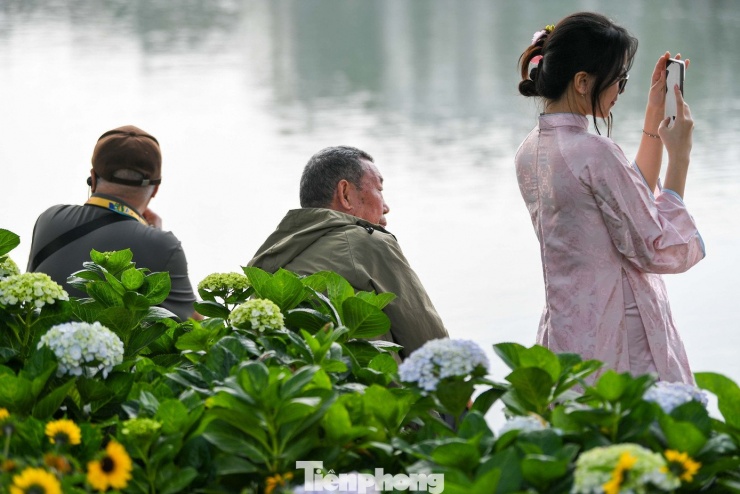 Mai Anh (21 tuổi, sinh viên tại Hà Nội) cho rằng việc mặc áo dài xuống phố không chỉ để lưu giữ hình ảnh cá nhân mà còn là cách cảm nhận Tết đang đến gần. “Khi thấy nhiều người mặc áo dài, trang trí quanh hồ cũng bắt đầu mang sắc xuân, mình có cảm giác Tết đến sớm hơn”, Mai Anh chia sẻ.