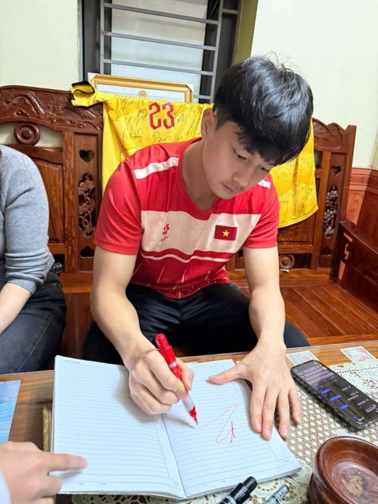 Tối muộn 26/1, thủ môn Cao Văn Bình đang tranh thủ ký tặng cho các fan nhí ở quê Diễn Châu, Nghệ An. Ảnh: Kiên Hà