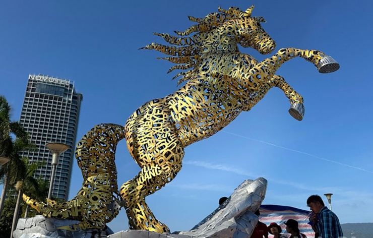 1770354059-linh_vat_ngua_10_0-width1200height764 Linh vật ngựa sắt vàng được ghép bằng tên 94 xã, phường, đặc khu Hoàng Sa và tên Thành phố Đà Nẵng đặt trước khu vực trung tâm hành chính thành phố, cạnh bờ sông Hàn. (Ảnh: Báo Nhân Dân)