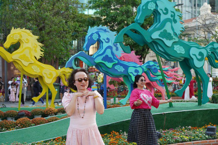 Khách chụp ảnh lưu niệm tại đường hoa Nguyễn Huệ TPHCM