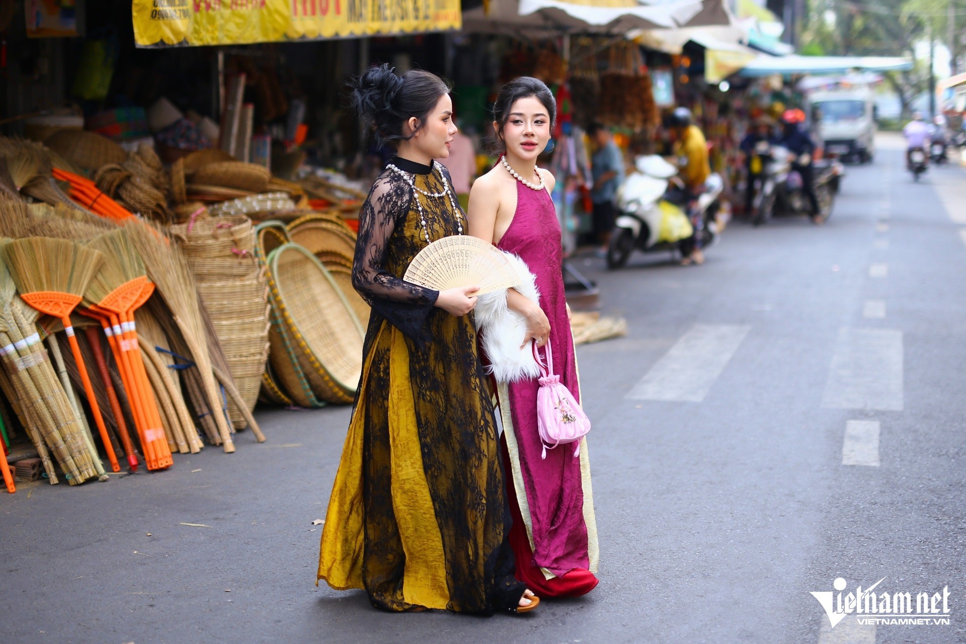 Từ sáng sớm, từng nhóm bạn trẻ đã có mặt, xúng xính trong tà áo dài truyền thống hoặc cách tân, tay cầm giỏ mây, hoa tươi, hòa mình vào dòng người mua bán rộn ràng. Các “nàng thơ” dạo bước chụp ảnh ở khu chợ, tạo nên bức tranh nhộn nhịp mùa xuân.