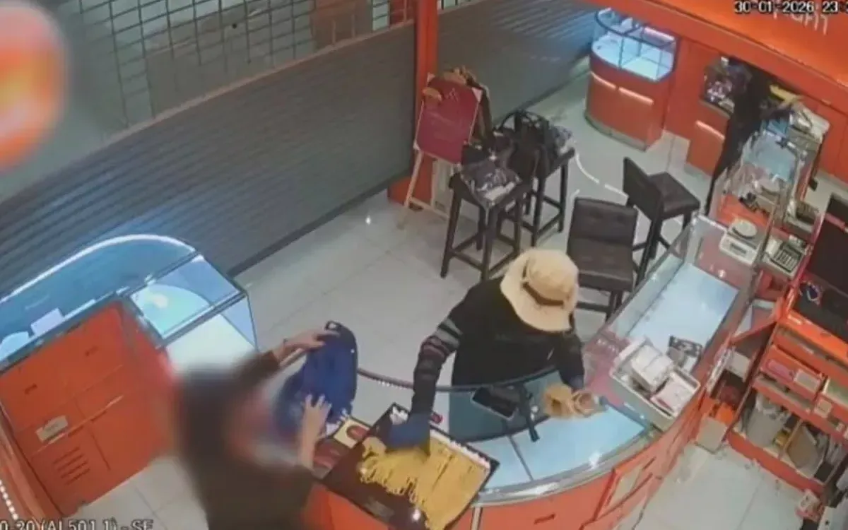 Hình ảnh trích xuất từ camera giám sát cho thấy nghi phạm lấy dây chuyền vàng tại tiệm vàng trong Trung tâm thương mại Lotus, đường Sukhumvit Soi 50, Bangkok, tối 30/1 (Ảnh: Bangkok Post)