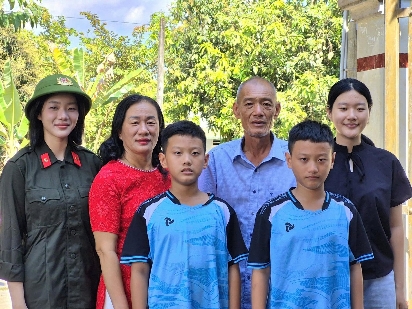 Châu Anh trong quân phục CAND, chụp ảnh kỷ niệm cùng gia đình. - Ảnh: NVCC